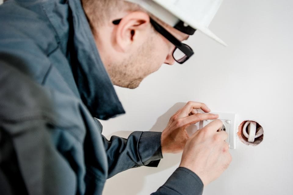Técnico de capacete trabalhando em uma instalação elétrica