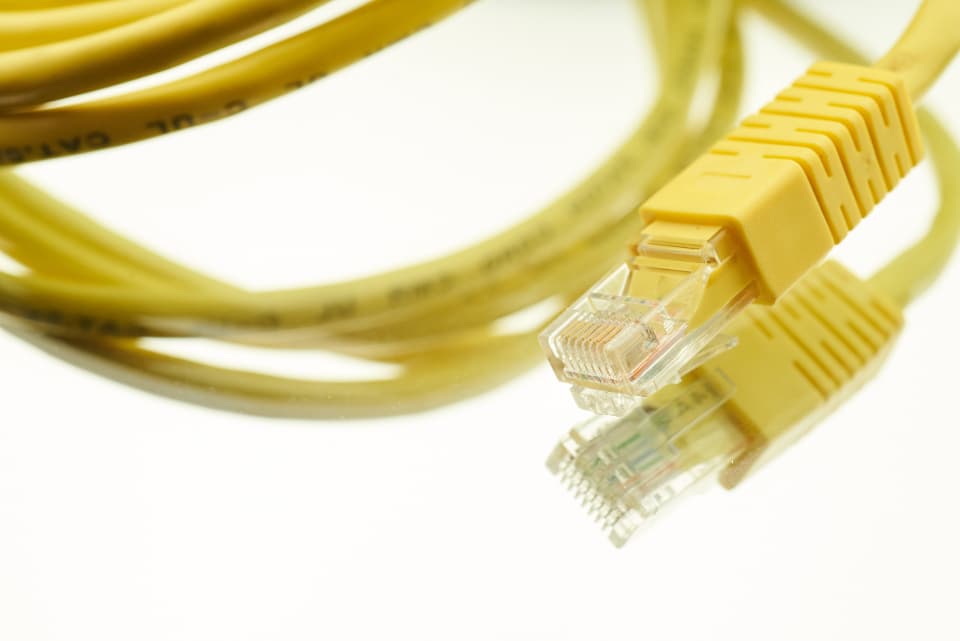 Cabo de rede amarelo com conector em destaque